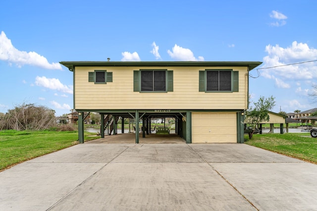 raised beach house featuring a front lawn, a garage, and a carport