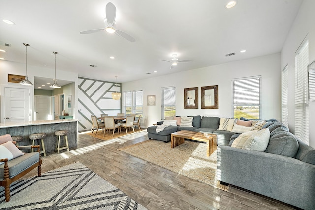 living room with wood-type flooring and ceiling fan