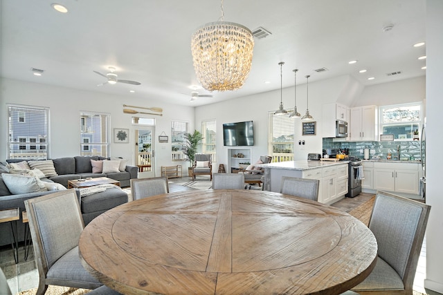 dining room featuring ceiling fan with notable chandelier and a wealth of natural light