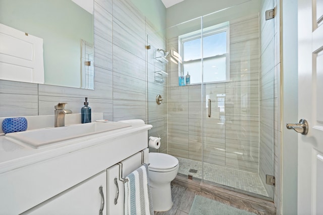 bathroom featuring an enclosed shower, tile walls, toilet, and large vanity