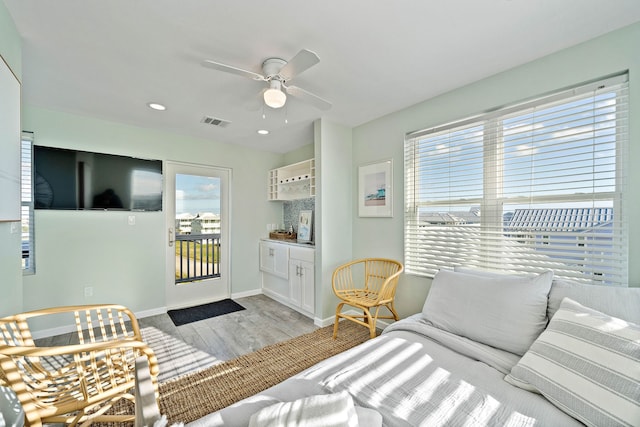 living room with a healthy amount of sunlight, light hardwood / wood-style flooring, and ceiling fan