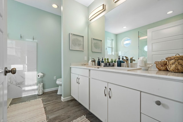 bathroom featuring hardwood / wood-style flooring, toilet, and oversized vanity