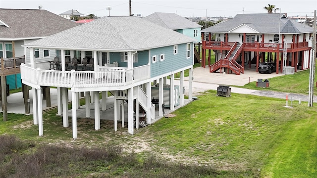 rear view of property featuring a wooden deck and a lawn