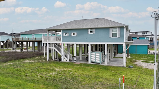 back of property with a wooden deck, a lawn, and a patio