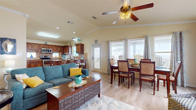 living room featuring vaulted ceiling, ceiling fan, ornamental molding, and light hardwood / wood-style flooring