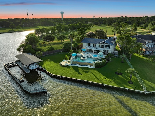 aerial view at dusk featuring a water view