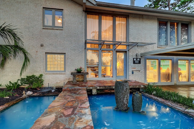 view of pool with pool water feature and a patio