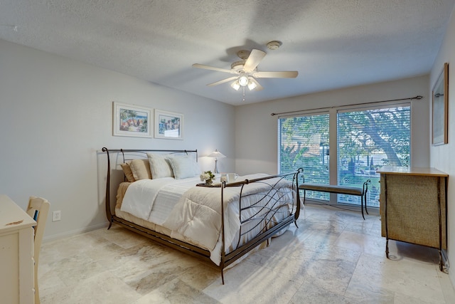 bedroom featuring ceiling fan and a textured ceiling