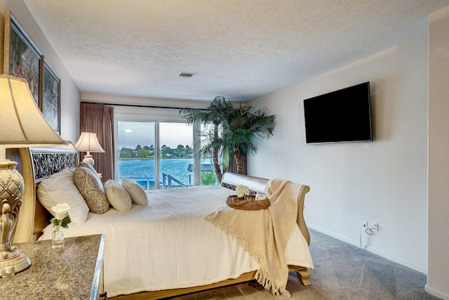 bedroom with carpet floors and a textured ceiling