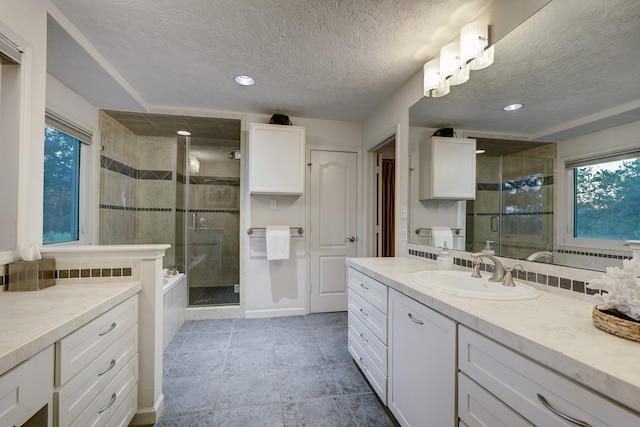 bathroom featuring vanity, a textured ceiling, and a shower with shower door