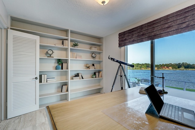 interior space with a water view and a textured ceiling