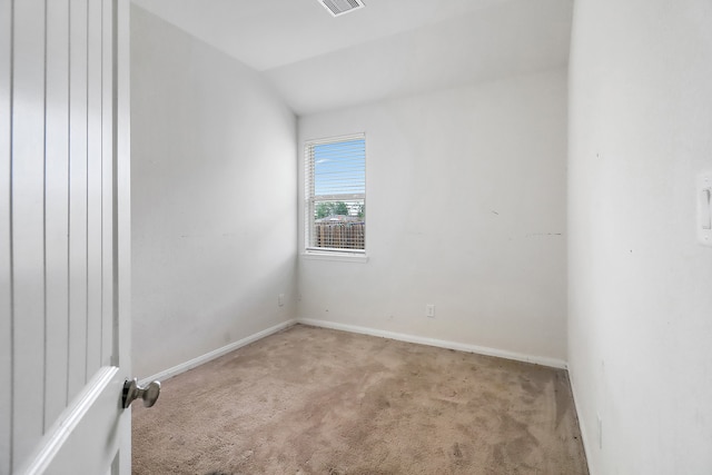 empty room featuring lofted ceiling and light colored carpet