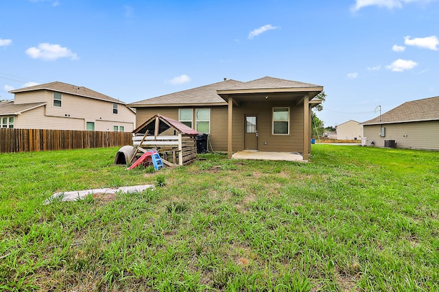 rear view of property with a lawn and a patio