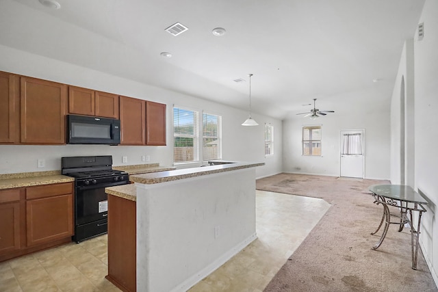 kitchen with ceiling fan, black appliances, a center island, pendant lighting, and light colored carpet