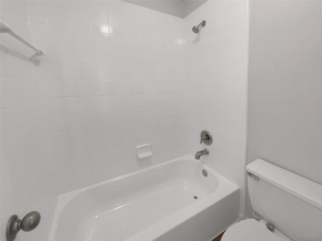 bathroom with tiled shower / bath combo and toilet