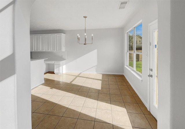 tiled empty room with a chandelier