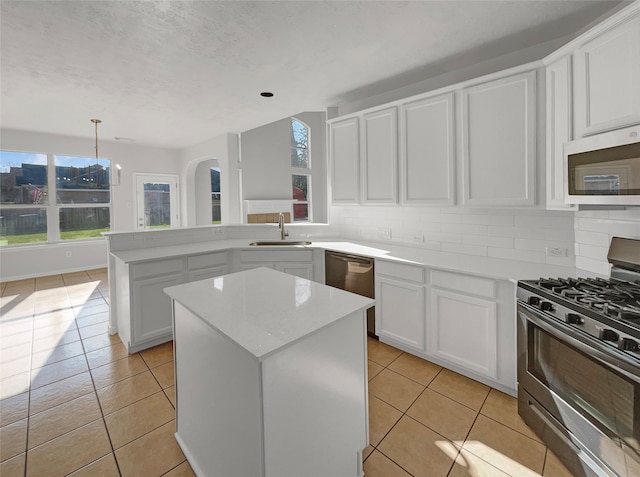 kitchen with a kitchen island, appliances with stainless steel finishes, tasteful backsplash, and sink