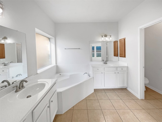 bathroom featuring double vanity, tile flooring, a bathtub, and toilet