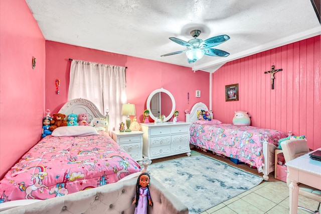 tiled bedroom featuring a textured ceiling and ceiling fan