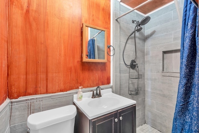 bathroom with tile walls, walk in shower, toilet, and vanity