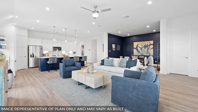 living room featuring ceiling fan and light wood-type flooring