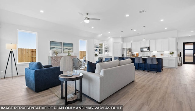 living room featuring light hardwood / wood-style floors and ceiling fan