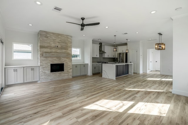 unfurnished living room featuring a fireplace, plenty of natural light, and light wood-type flooring