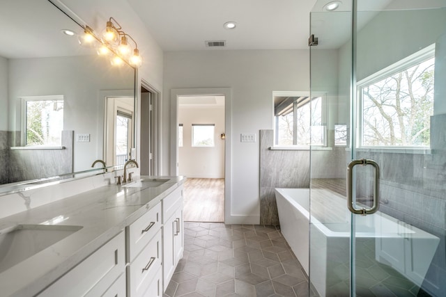 bathroom featuring tile flooring, separate shower and tub, tile walls, and double vanity