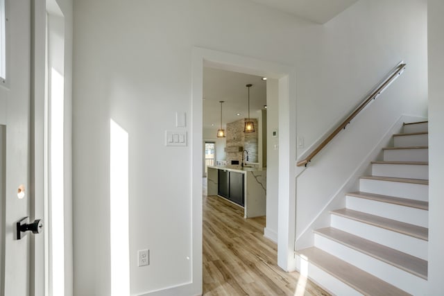 staircase with sink and light wood-type flooring