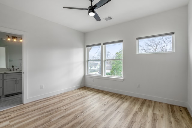 spare room with sink, light hardwood / wood-style floors, and ceiling fan