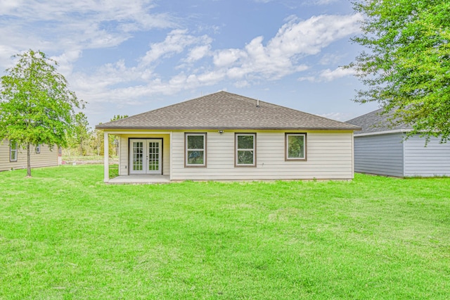 back of property with french doors and a yard