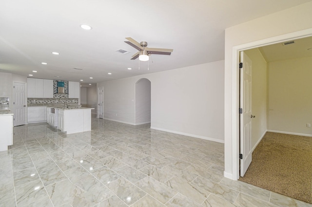 unfurnished living room featuring ceiling fan