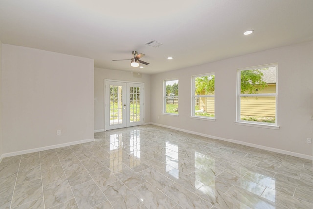 empty room featuring ceiling fan and french doors