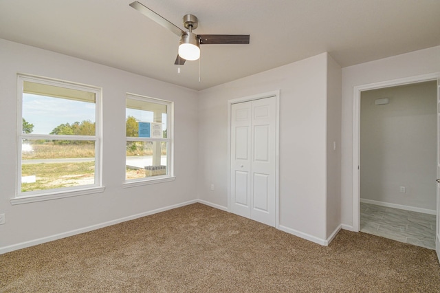 unfurnished bedroom with a closet, carpet, and ceiling fan