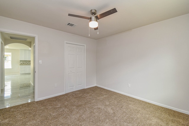 unfurnished bedroom with carpet floors, ceiling fan, and a closet