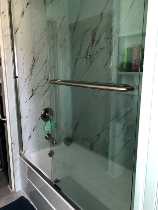 bathroom with shower / bath combination with glass door