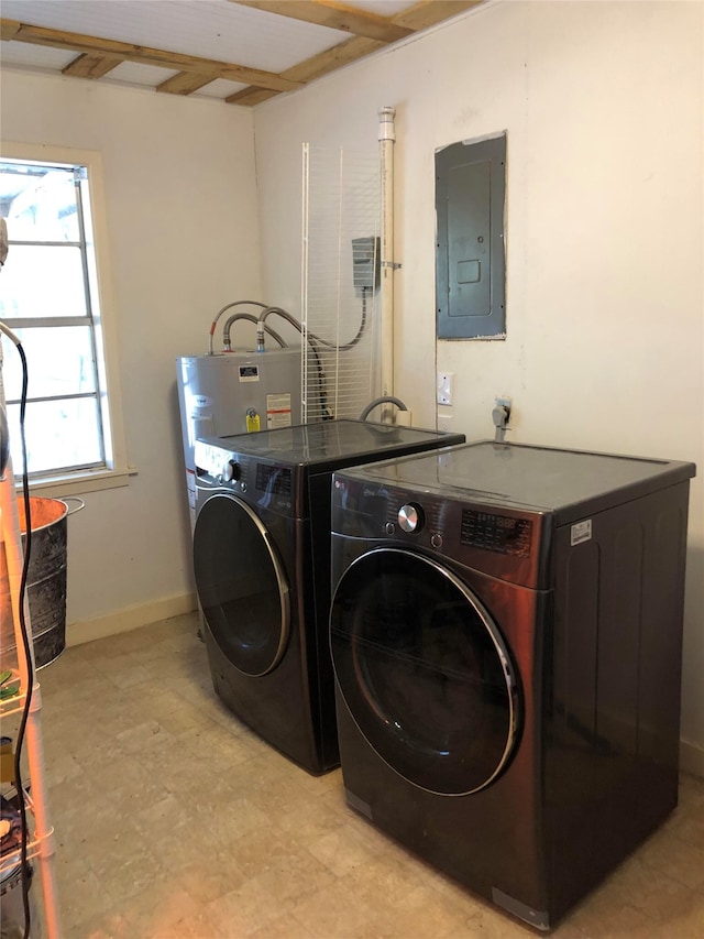 washroom with light tile patterned flooring, gas water heater, washing machine and dryer, and electric panel