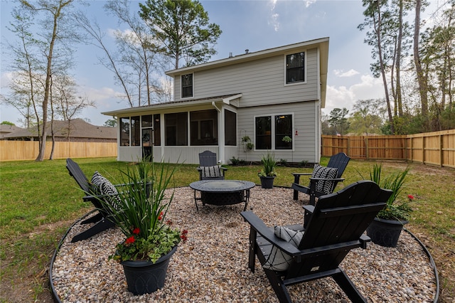 rear view of property featuring a yard, a fire pit, and a sunroom