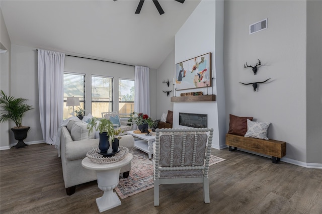 living room featuring vaulted ceiling, ceiling fan, and dark wood-type flooring