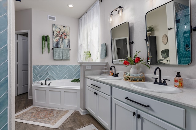 bathroom with a washtub, hardwood / wood-style floors, and vanity