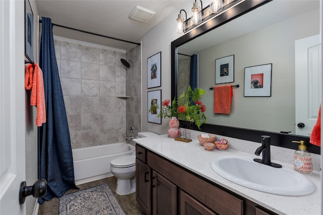 full bathroom with vanity, toilet, shower / bath combo with shower curtain, a textured ceiling, and wood-type flooring