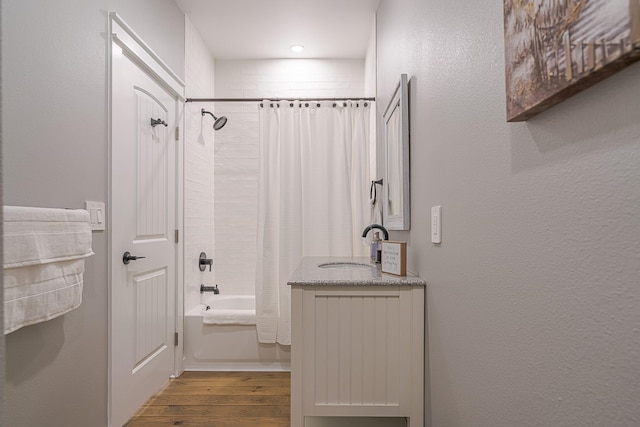 bathroom featuring hardwood / wood-style flooring, vanity, and shower / tub combo