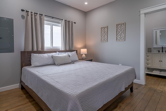 bedroom with sink, dark wood-type flooring, and electric panel