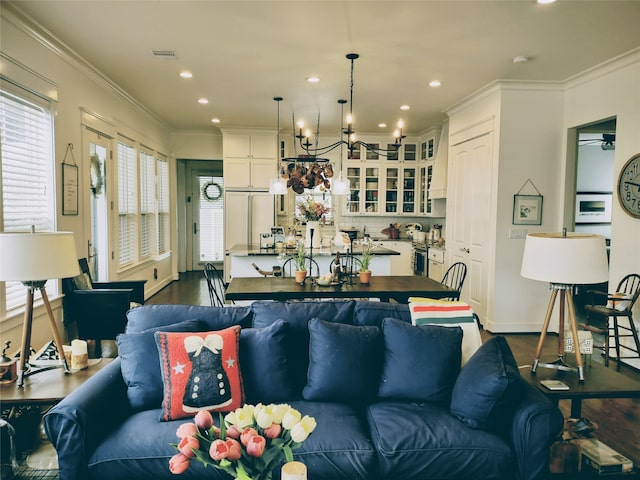 living room with ornamental molding, a chandelier, and hardwood / wood-style flooring