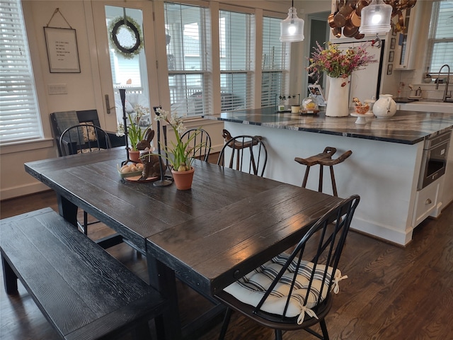 dining space with dark hardwood / wood-style flooring and sink