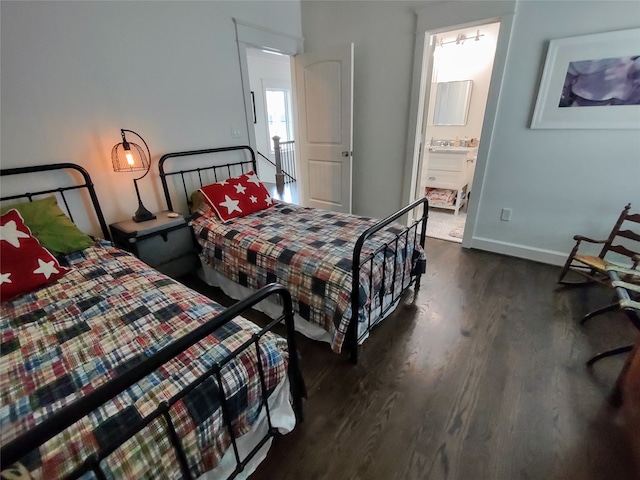 bedroom featuring connected bathroom, sink, and dark hardwood / wood-style floors