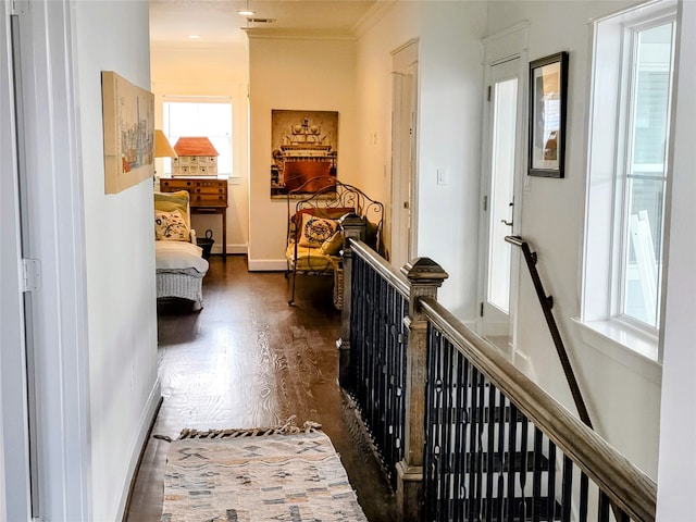 hall with dark wood-type flooring and ornamental molding