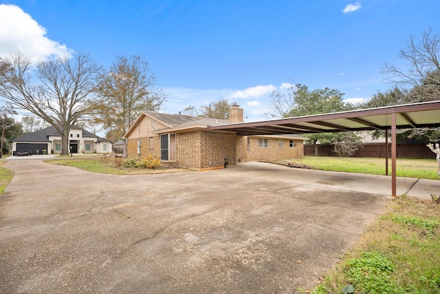 view of property exterior with a carport and a lawn