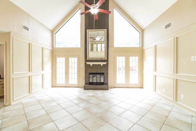 unfurnished living room featuring high vaulted ceiling, ceiling fan, and a brick fireplace