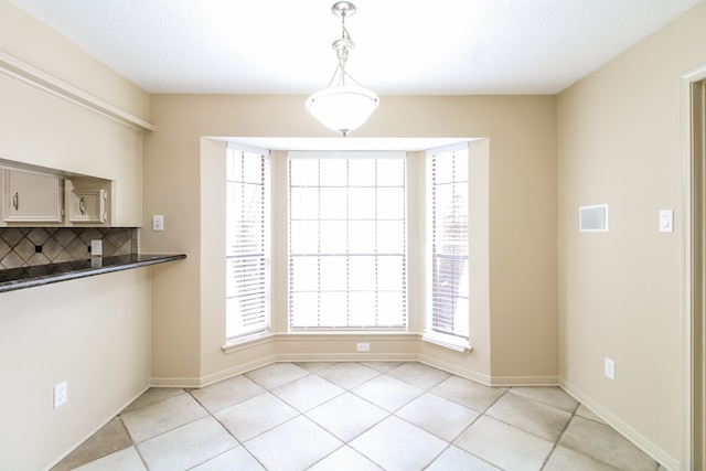 unfurnished dining area featuring plenty of natural light and light tile patterned flooring